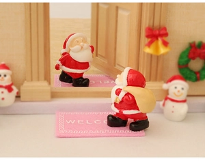 Miniature Christmas scene with Santa Claus, snowmen, and festive resin decorations