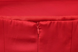 Détail de la fermeture éclair invisible et du tissu en satin rouge du haut bustier