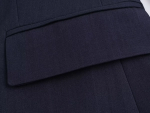 Close-up of navy blue blazer pocket detailing and high-quality polyester fabric texture