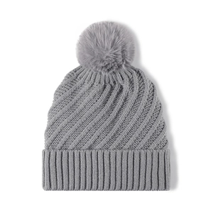 Grey waffle knit beanie for women with faux fur pom pom and ribbed cuff on white background