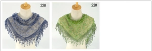 Detail of vintage floral lace shawls in dark blue and green with embroidery and tassels