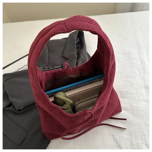 Spacious burgundy suede tote bag interior showing capacity for laptop and daily essentials