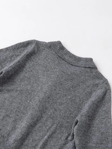 Dettaglio ravvicinato di una polo in maglia grigia con trama del colletto e cuciture