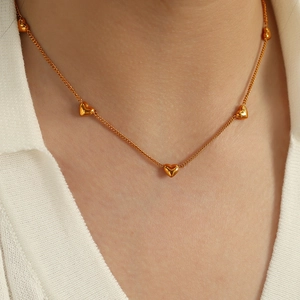 Golden heart necklace with five small 3D pendants on a thin link chain for women