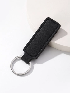 Close-up of minimalist black PU leather keychain with fine stitching and silver metal ring