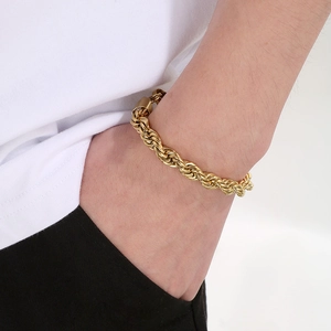 Gros plan d'un bracelet gourmette dorée porté au poignet pour un look tendance