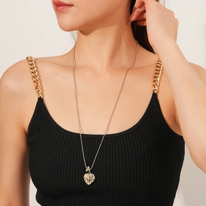 Detail of cross necklace with marbled heart pendant and star inlay on model