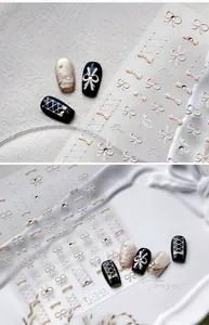 Detail of 3D embossed nail stickers featuring white bows and gold lace-up ribbons
