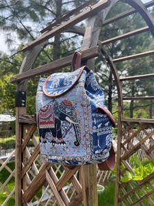 Detailed view of blue ethnic canvas backpack featuring elephant patterns and geometric motifs