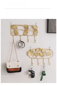 Detail of golden ginkgo leaf metal wall hooks showcasing bag and key hanging scenario