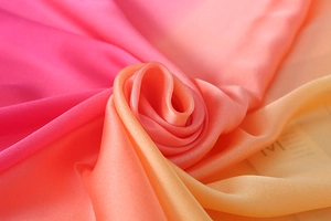 Detailstruktur des Seidensatins mit rosa-orangefarbenem Farbverlauf in Rosenform