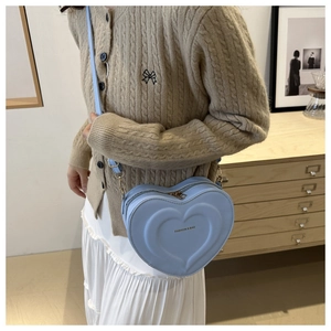 Close-up of light blue heart-shaped PU leather bag with embossed texture and zipper detail