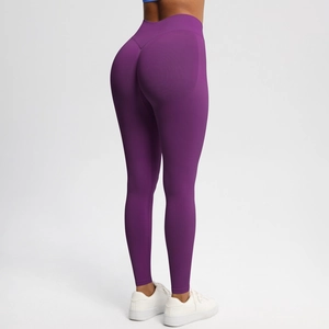 Detail view of seamless high-waist yoga leggings in deep purple with peach lift stitching