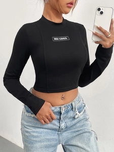 Eng anliegendes schwarzes Langarm-Crop-Top mit WHO CARES Print und Stehkragen