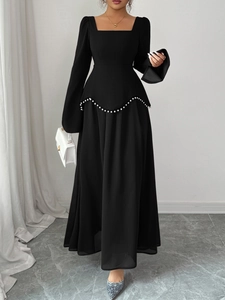 Robe de soirée noire à manches longues avec taille en V perlée et jupe évasée fluide