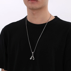 Hip hop titanium steel boxing gloves pendant necklace worn by male model on black tee