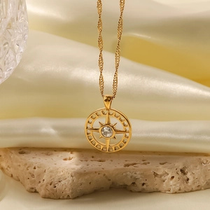 Close-up of gold starburst heart pendant with white zircon on silk and raw stone background