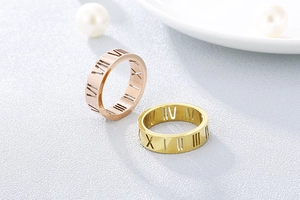 Detail view of hollow Roman numeral rings in gold and rose gold with polished finish