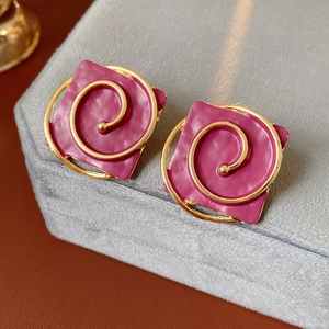Macro detail of magenta square earrings with vintage gold spiral painted accents