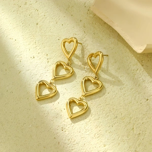 Detailed view of triple hollow heart dangle earrings in 18K gold plated stainless steel
