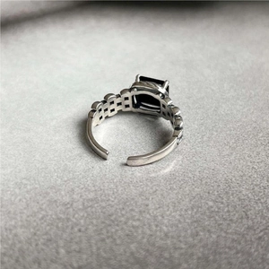Macro view of vintage silver ring featuring black gemstone and hollow carved band
