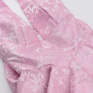 Detailed view of pink floral jacquard fabric and cross V-neck stitching on the dress