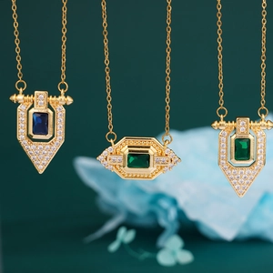Vintage gold necklaces with emerald and sapphire stones surrounded by sparkling diamonds