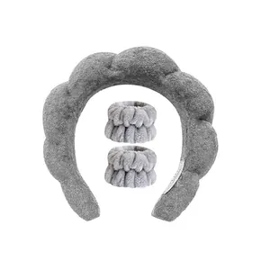 Close-up of plush grey spa headband and matching wristbands set for face washing