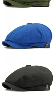Detail of newsboy caps in green, blue, and black with side leather straps and metal rivets