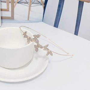 Elegant rose gold metal headband with sparkling rhinestone butterflies on a white cup