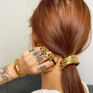 Golden chunky bracelet and croissant hair cuff accessory on a ponytail for women
