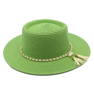 Détail du chapeau de paille vert avec chaîne dorée, perles blanches et pompons