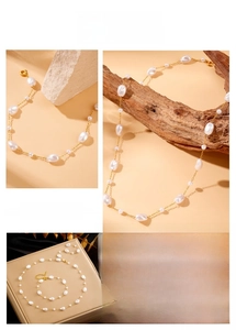 Detailed view of baroque pearls on gold stainless steel chain necklace and bracelet set