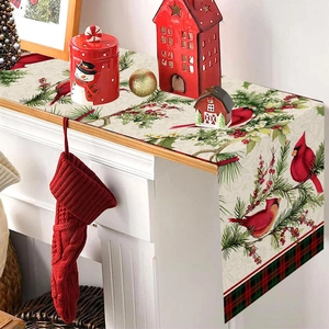 Christmas table runner with red cardinal and pine branches on festive fireplace