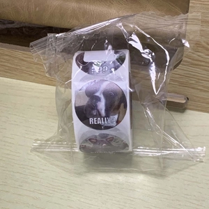 Detailed view of round pet meme stickers on a roll featuring funny pet expressions