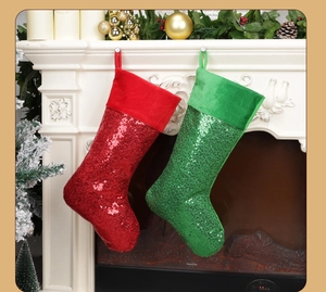 Pair of large red and green sequin Christmas stockings hanging on a white fireplace
