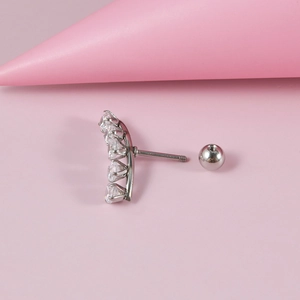 Detailed view of silver stainless steel curved earring with five clear cubic zirconia gems
