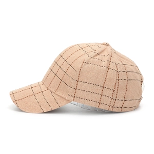 Detail of beige plaid fabric texture and stitching on structured baseball cap