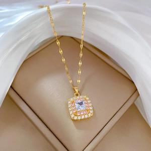 Detail of gold square pendant with pink crystals and clear diamonds on silk