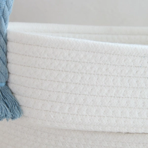 Detailed close-up of woven cotton rope texture with a blue decorative knot accent