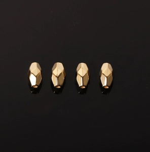 Macro shot of four golden geometric faceted CCB spacer beads for DIY jewelry making