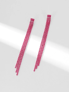 Detail von eleganten langen Quastenohrringen mit funkelnden rosa Strasssteinen auf Metall