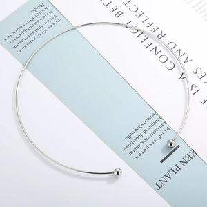 Detail of silver stainless steel torque choker with screw-on beads on blue card