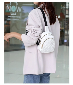 White quilted mini crossbody backpack with gold zippers and black woven strap