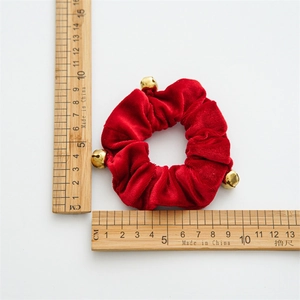 Red velvet scrunchie with gold bells on white background showing 9cm diameter size