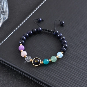 Blue goldstone beaded bracelet with Libra zodiac charm on black leather background