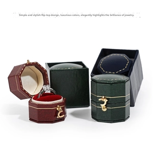 Macro detail of octagonal leather jewelry boxes with metallic latches and velvet interior
