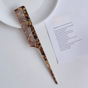 Detailed view of acetate fine-tooth tail comb with classic tortoiseshell pattern finish
