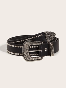Close-up of a black punk rock belt with silver studs and western floral carved metal buckle