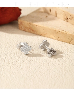 Macro detail of silver clover earrings with micro-pave white zircon and butterfly backs
